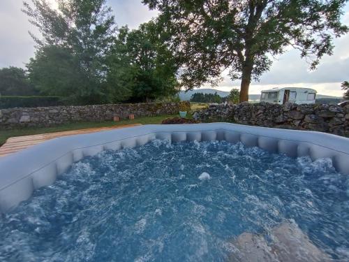 - un bain à remous dans l'arrière-cour d'une maison dans l'établissement Caravane Vintage Atypique avec jacuzzi à la campagne, à Sauvessanges