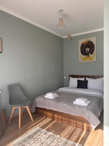 a bedroom with a bed and a chair in it at Guesthouse Relax in Kazbegi in Stepantsminda