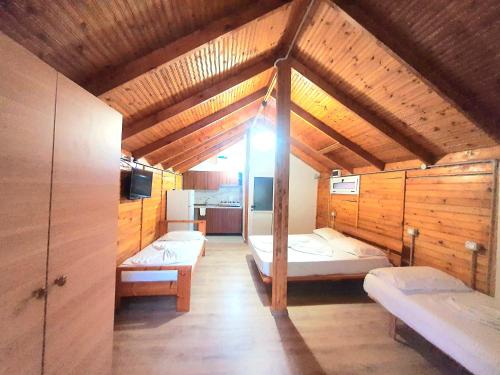 a room with three beds in a wooden house at TONEDA Seaside Bungalows in Dhërmi