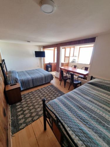 a bedroom with two beds and a table with a desk at Al Mar Cabañas in Viña del Mar