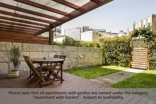a patio with a table and chairs and a stone wall at Apartment Boavista Roundabout by Sweet Porto in Porto