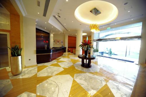 una hall con pavimento piastrellato in giallo e bianco. di Monaco Hotel a Dubai