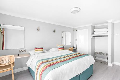 a bedroom with a large bed with a colorful blanket at Waters Edge Hotel Torquay in Torquay