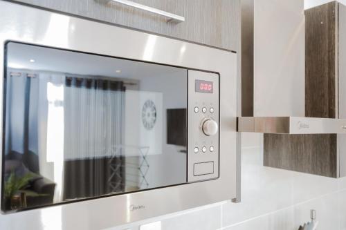 a microwave oven on a wall in a kitchen at Accra Luxury Apartments at Embassy Gardens in Accra