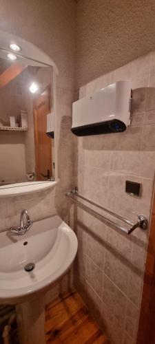 une salle de bain avec un lavabo blanc et un miroir dans l'établissement L'esprit chalet près des pistes, à Bolquère-Pyrénées 2000