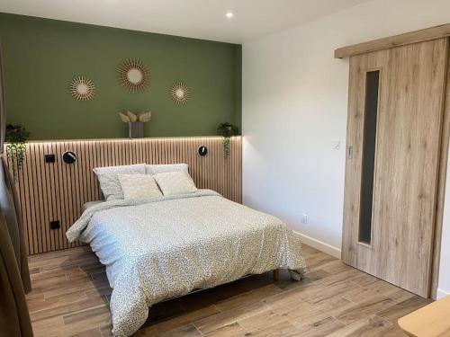 a bedroom with a bed and a green wall at Gite 2 du grand Pavillon in Rocroi
