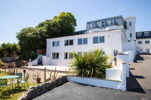 a white building with a table and a patio at Waters Edge Hotel Torquay in Torquay