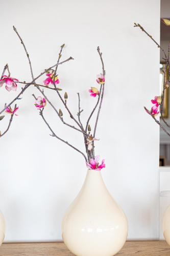 a white vase with pink flowers in it at Waters Edge Hotel Torquay in Torquay