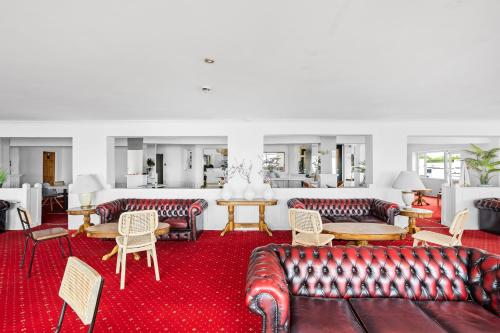 a living room with leather couches and tables at Waters Edge Hotel Torquay in Torquay