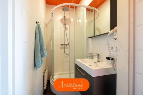 ズワーネンブルクにあるAmsterdam Group Stay - 26 Beds - Jacuzzi & Saunaのガラスのシャワーと洗面台を備えたバスルーム