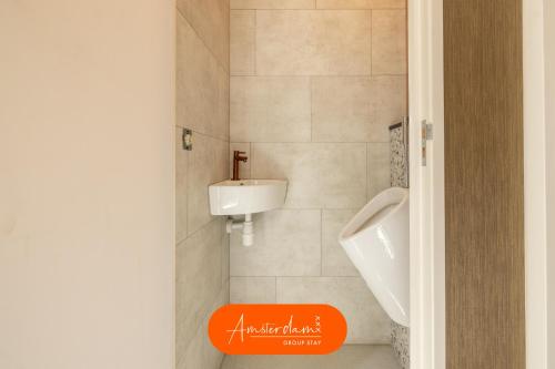 a bathroom with a urinal and a sink at Amsterdam Group Stay - 26 Beds - Jacuzzi & Sauna in Zwanenburg