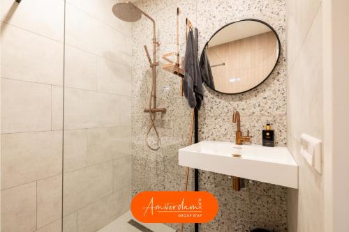 a bathroom with a sink and a mirror at Amsterdam Group Stay - 26 Beds - Jacuzzi & Sauna in Zwanenburg