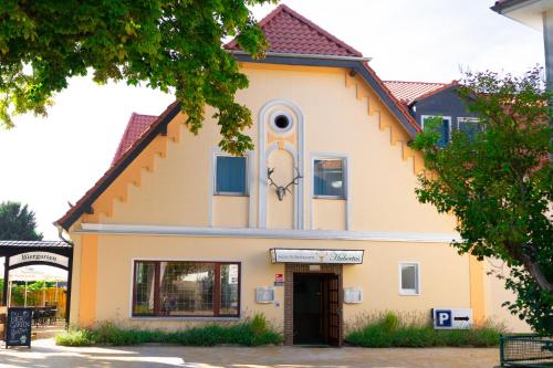 a yellow and white building with a door at Hotel & Restaurant Hubertus Sehnde in Sehnde