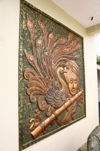 a mosaic of a woman with a peacock on a wall at Gokulam Grand in Srikalahasti