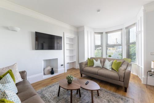 a living room with a couch and a table at Glenmoriston Town House Apartments in Inverness