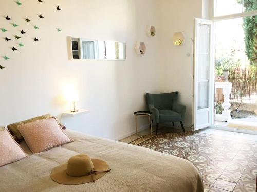 une chambre avec un lit avec un chapeau dessus dans l'établissement Magnifique Appartement avec cour extérieure privée, à Aix-en-Provence