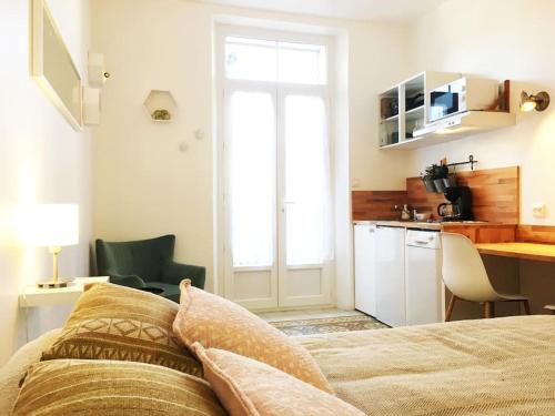 une chambre avec un lit et un bureau et une cuisine dans l'établissement Magnifique Appartement avec cour extérieure privée, à Aix-en-Provence