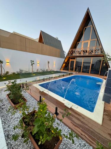a building with a swimming pool in front of a building at شاليهات اكواخ كايا الفندقية in Khalij Salman