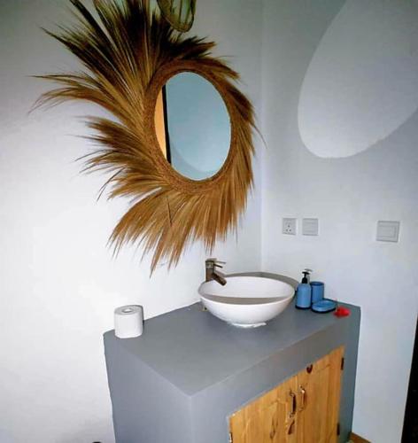 a bathroom with a sink and a mirror on a counter at Kikadini Villa with private pool in Jambiani