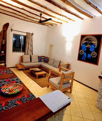 a living room with a couch and a table at Kikadini Villa with private pool in Jambiani