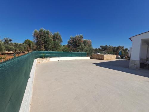 a large concrete patio with a green fence at Virginia Country house in Specchiolla 