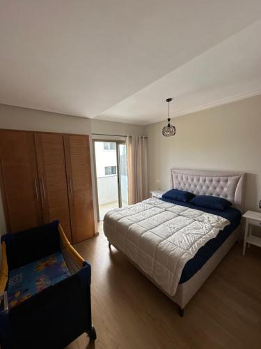 a bedroom with a large bed and a chair at Luxury apartment Malabata hills in Tangier