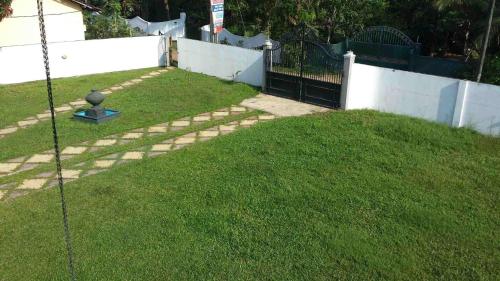 a yard with a fence and green grass at Pasidu Villa in Kalutara