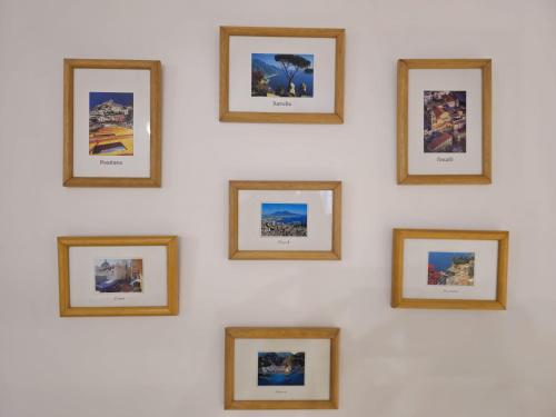 a wall of framed photos on a white wall at CasaFiore Guest House in Vietri sul Mare