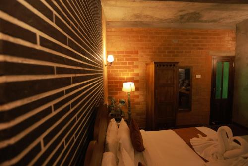 a bedroom with a brick wall and a bed at Villa Ecotiva in Puducherry