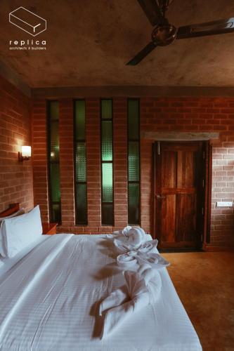 a white bed with flowers on it in a room at Villa Ecotiva in Puducherry