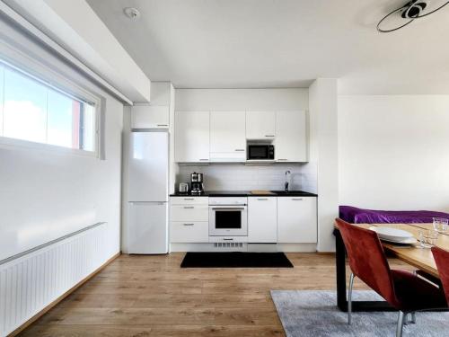 una cocina con un refrigerador blanco y una mesa y una mesa en Top floor, en Espoo
