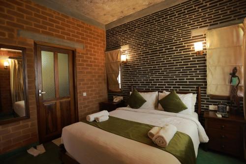 a bedroom with two beds and a brick wall at Villa Ecotiva in Puducherry