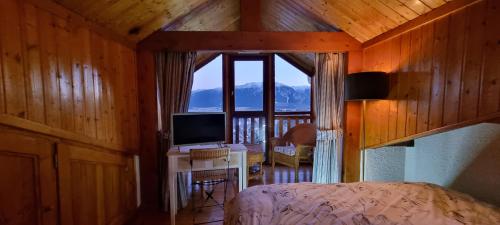 une chambre avec un lit et une grande fenêtre dans l'établissement L'esprit chalet près des pistes, à Bolquère-Pyrénées 2000