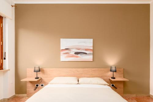 una camera da letto con un letto bianco e due lampade di Design Retreat a Saluzzo - Comfort e Stile Unico a Saluzzo