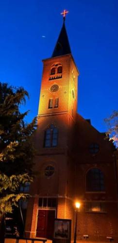 a building with a tower with a cross on top at B&B CaSandra in Volendam