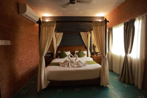 a bedroom with a bed with a canopy at Villa Ecotiva in Puducherry