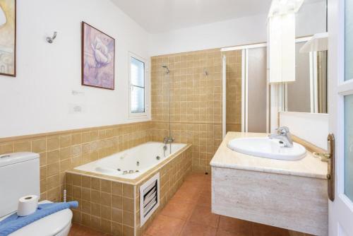 a bathroom with a tub and a sink and a toilet at Villa Adella in Tías
