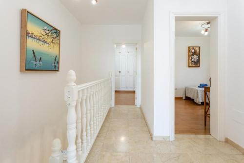 a white staircase in a home with a painting on the wall at Villa Adella in Tías