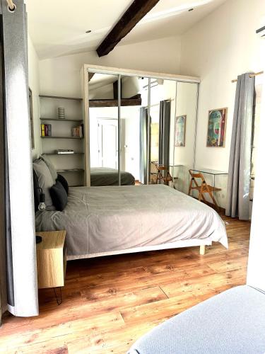 une chambre avec un grand lit et un grand miroir dans l'établissement Maison Arenas, à Arles