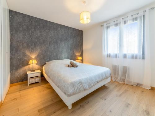 une chambre avec un lit blanc et un mur dans l'établissement Appartement 3 Pièces PROCHE DU LAC avec TERRASSE, à Annecy