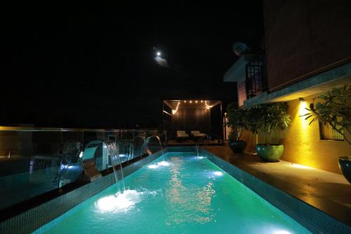 a swimming pool at night with a fountain at Villa Ecotiva in Puducherry