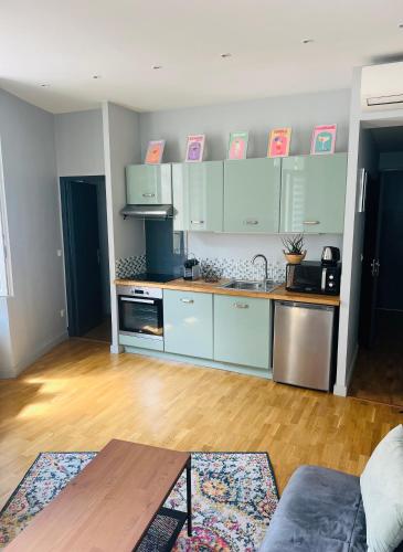 Il comprend une cuisine avec des placards bleus et du parquet. dans l'établissement Appartement avec balcon, centre Cannes, à Cannes