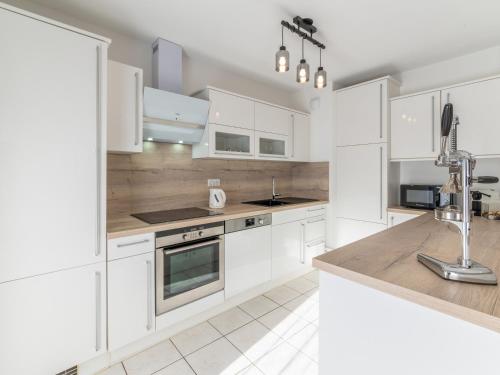 une cuisine blanche avec des placards blancs et un comptoir dans l'établissement Appartement 3 Pièces PROCHE DU LAC avec TERRASSE, à Annecy