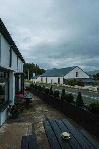 a bench in front of a building and a street at Lake House & Private Pub Kerry - Large Groups up to 26 People in Kenmare
