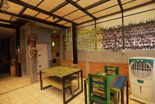 a patio with a table and chairs and a table and a heater at Villa Ecotiva in Puducherry