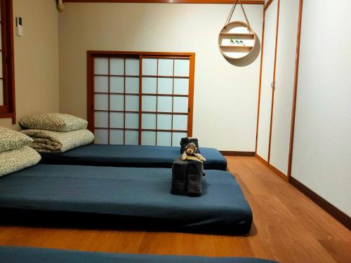 a room with two beds with a doll sitting on it at 豆インMaMe Inn in Saitama