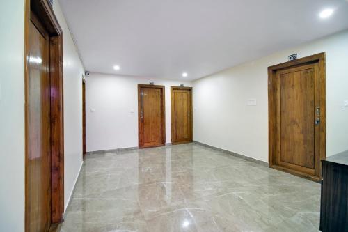 an empty room with wooden doors and a tile floor at beestay Hotels Visakhapatnam in Visakhapatnam
