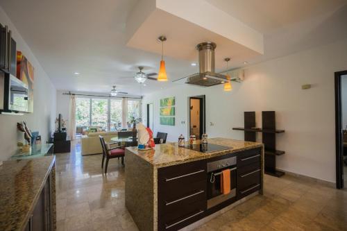 a kitchen with a counter and a living room at Playa Village Condo by BVR in Playa del Carmen