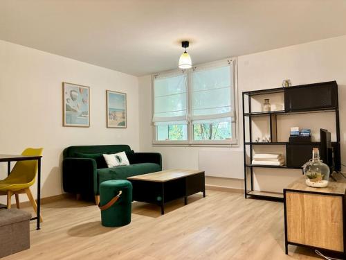 un salon avec un canapé vert et une table dans l'établissement Appartement Indépendant, tout confort avec terrasse, à Valence