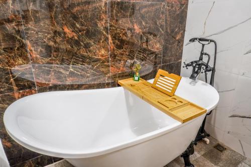 une salle de bain avec une baignoire blanche et un lavabo dans l'établissement Oka tagaytay escape, à Casile